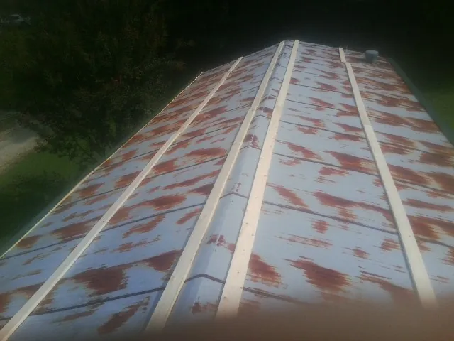 Rusted metal roof panels with new wood purlins before replacement — Storm Damage Roof Repair in Slade by Roofing Brothers