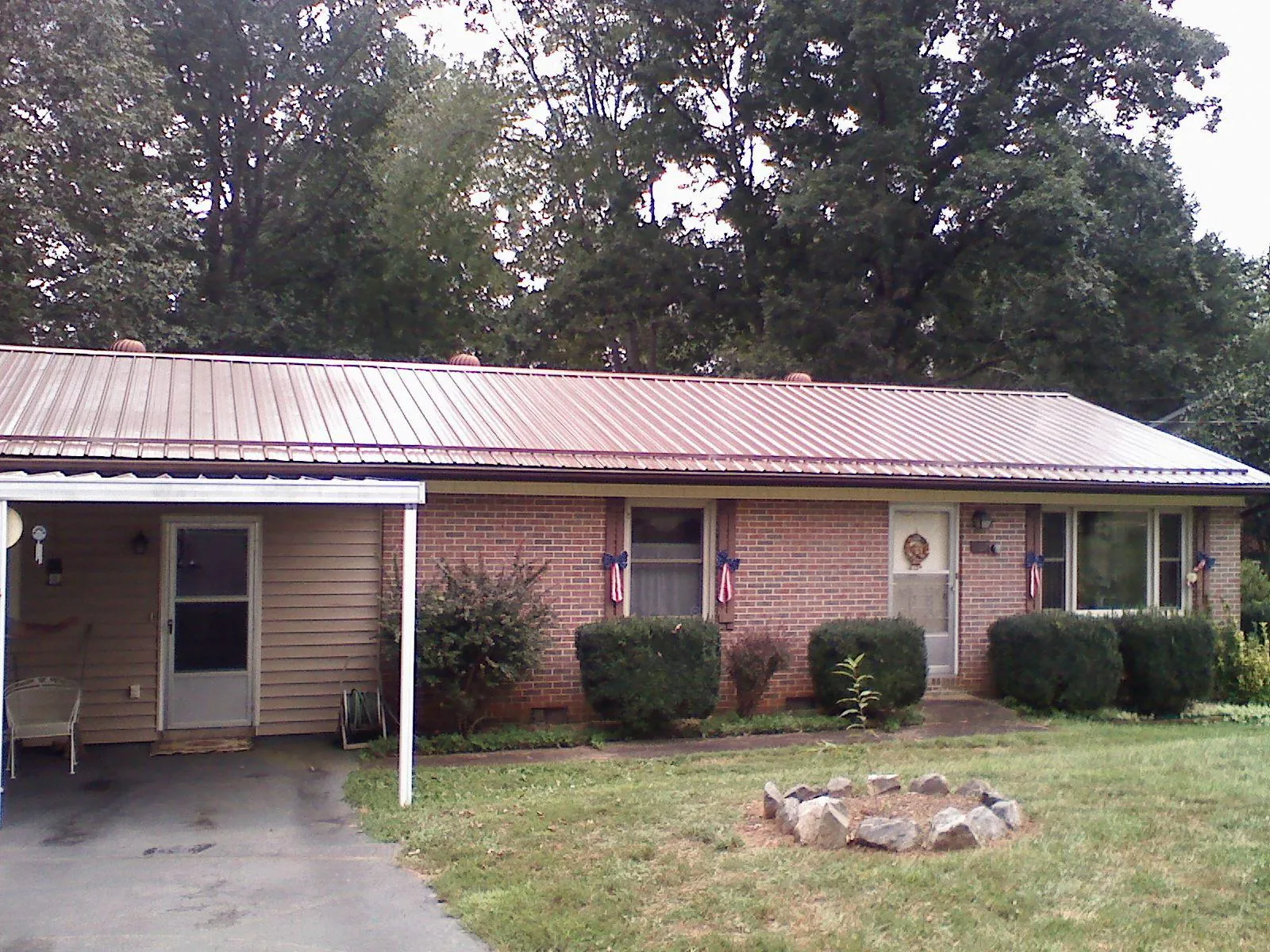 Bronze metal roof and carport on a brick ranch home — Roof Repair work by our crew in Slade